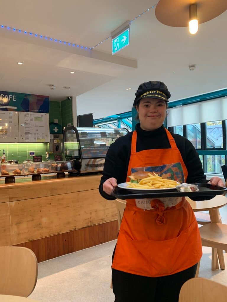 Student working at café delivering customer their food order.